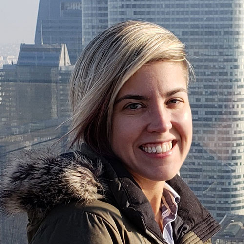 Headshot photo of Lauren Ryley against a city background.