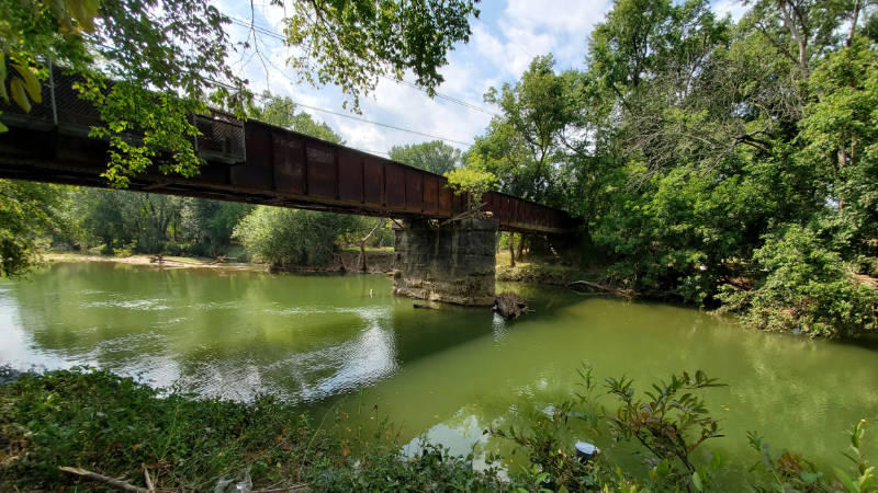 Algal bloom in Brandywine Creek where it flows under a railroad bridge.