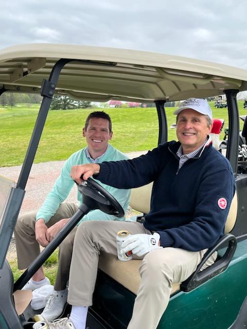 Two men in a golf cart at the 2022 Fore Fresh Water golf outing.