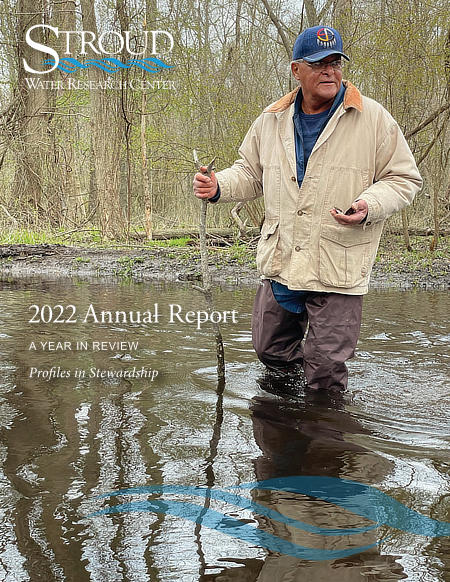 2022 Annual Report cover image of a Native American man standing in a stream.
