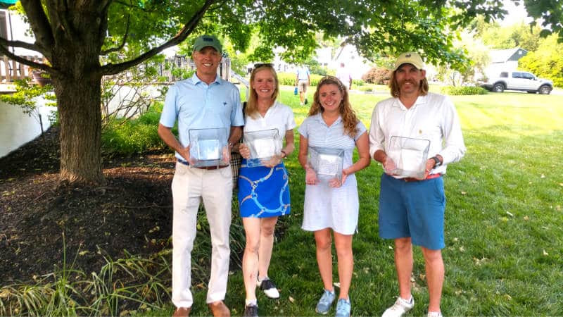 Four golfers holding their awards.