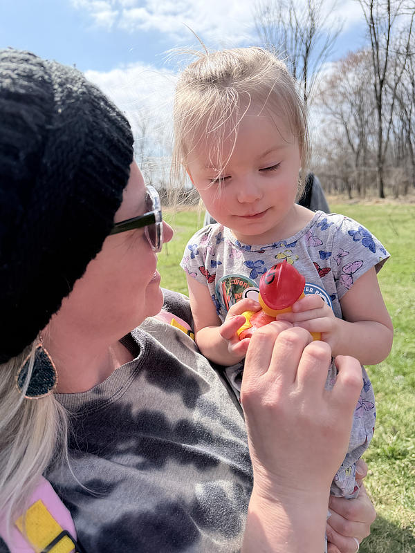A mother holds a toddler with a rubber duckie.