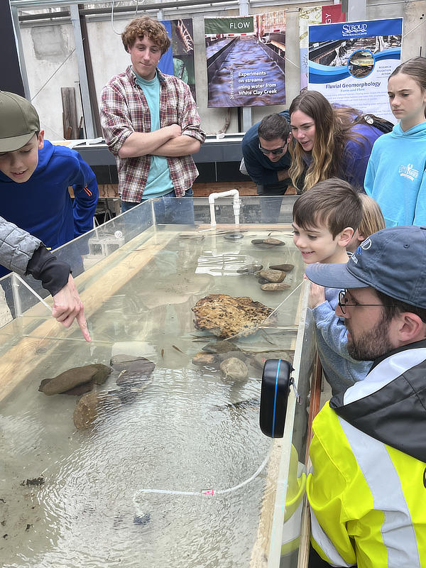 Adults and children gather around a live fish tank at World Water Day.