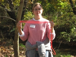 Education programs manager Christina Medved shows off the onion bag, a critical component of the Leaf Pack Experiment.