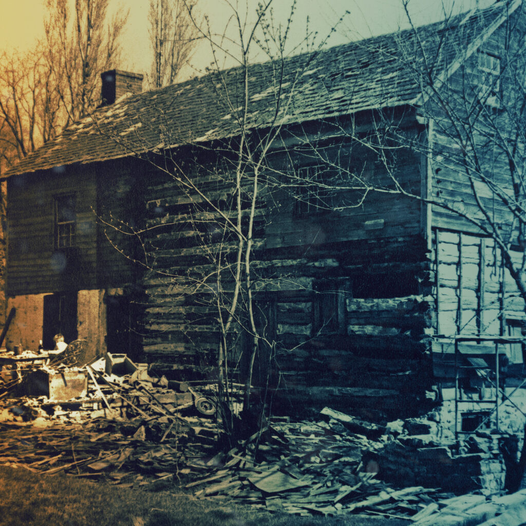 W.B. Dixon Stroud Sr. reviews cabin restoration plans while sitting in construction debris.