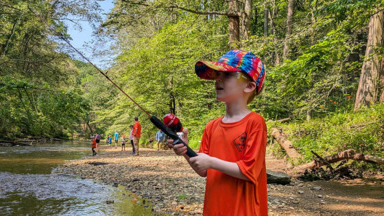 A Cub Scout learns to fish in the Junior Rangers Angler program.