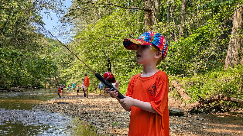 A Cub Scout learns to fish in the Junior Rangers Angler program.
