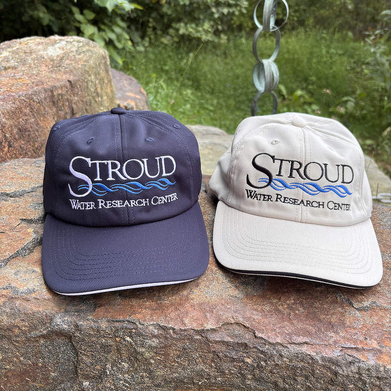Dark blue and light tan Stroud Center ball caps.