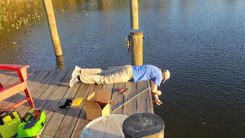 Scott Ensign working on a dock, head under heels for science.