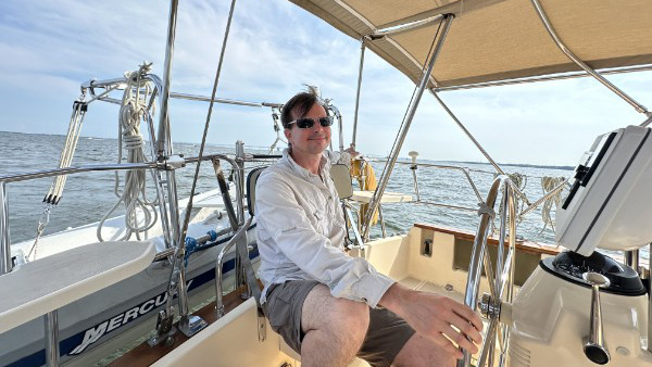Scott Ensign piloting a sailboat.