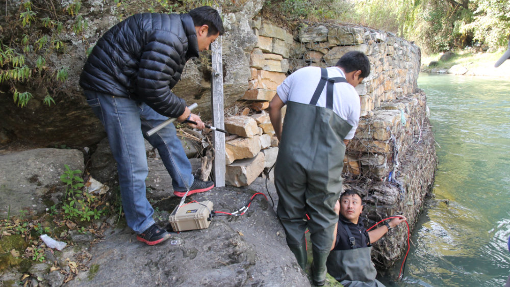 Installing water quality monitoring sensors in Thimphu River, Bhutan.