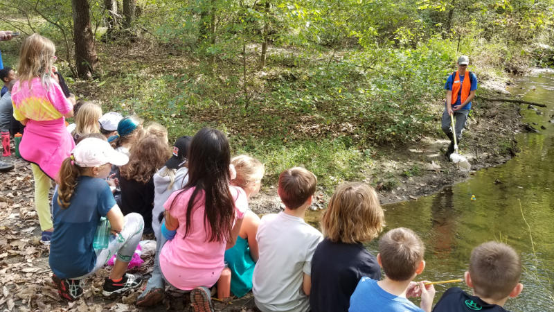 An educator prepares to catch a rubber duck in White Clay Creek.