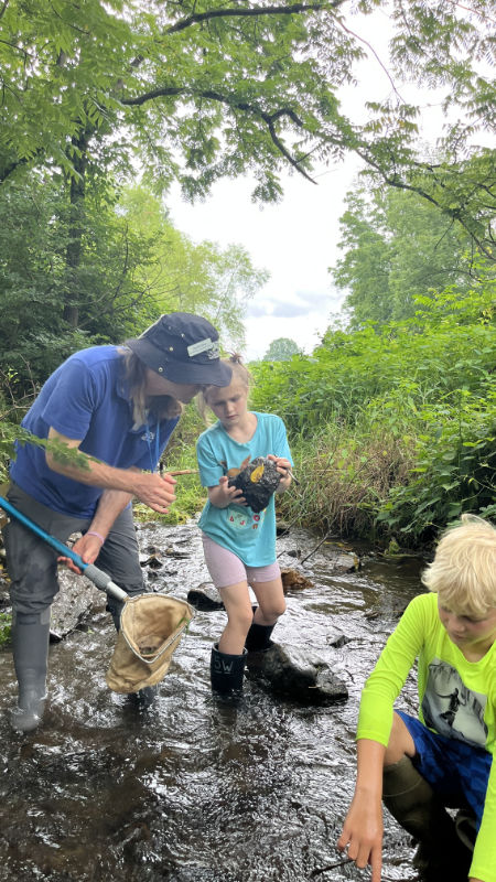 Summer campers in collect macroinvertebrates from a stream.