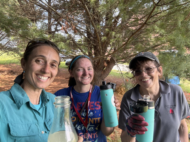 Teachers hydrate after planting a pollinator garden.