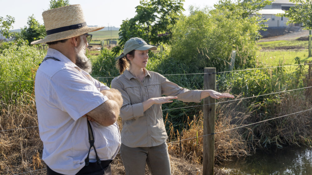 Watershed restoration team member with Amish farmer.