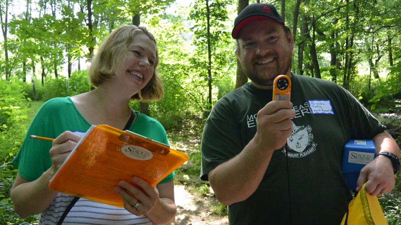 Photo of two teachers, one with a compass, and one with a clipboard, in the outdoor classroom