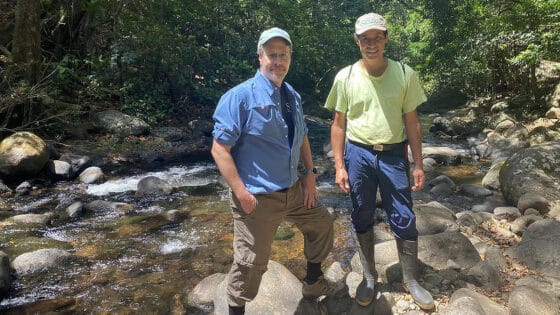 David Arscott and Rafa Morales stand in a stream in Costa Rica.