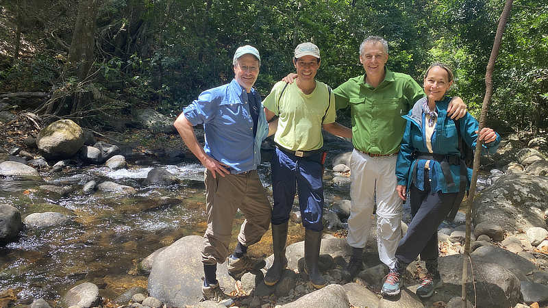 Three men and a woman standing next to a Costa Rican stream.