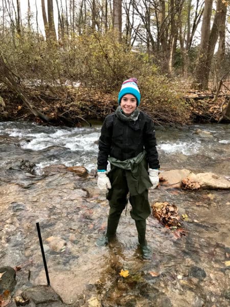 Maggie Auman checking on her leaf packs in a stream.
