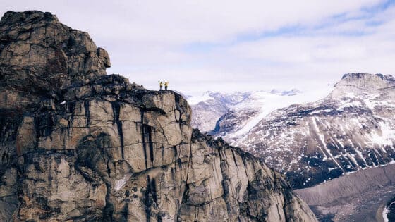 Two people standing on the top of a mountain.