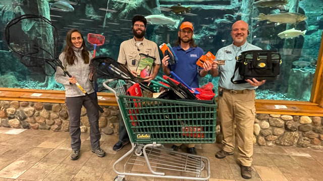 Stroud Center and Cabela's staff members with a shopping cart of donated gear.