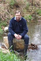 Bern Sweeney sitting on a rock in White Clay Creek
