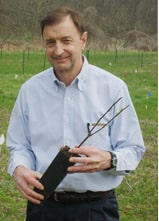 Bern Sweeney holds a sapling.