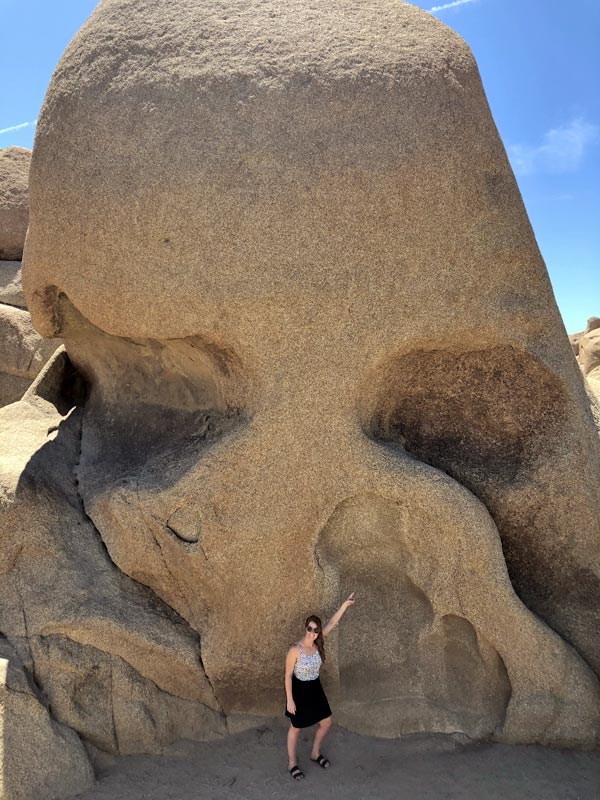 Katie Billé standing next to Skull Rock in Joshua Tree National Park, California.