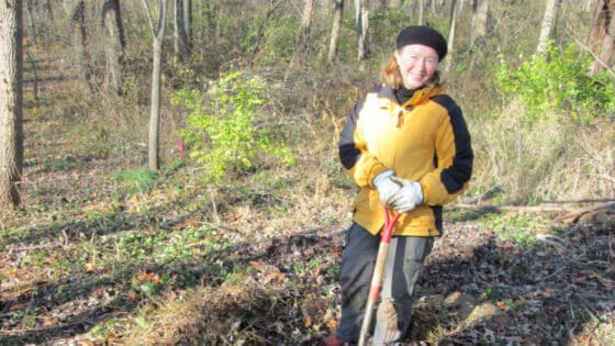 Carol Armstrong plants a tree in a streamside forest.