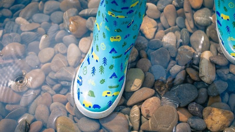 Photo of a child's boots standing in shallow water