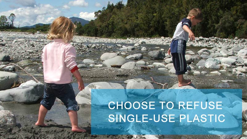 Photo of two children on rocks at a lake's edge, with text that says Choose to Refuse Single-Use Plastic.
