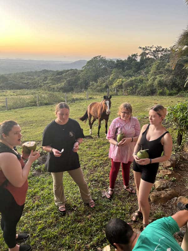 Four college students sample fresh coconut in Costa Rica.