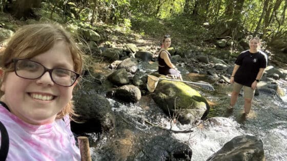 Three college students take a selfie in a Costa Rican stream.