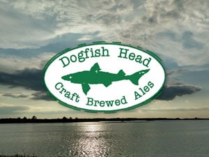 Dogfish Head Craft Brewed Ales logo over a photo of a sunset.