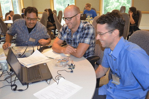 Three men learn about DIY environmental monitoring at a workshop.