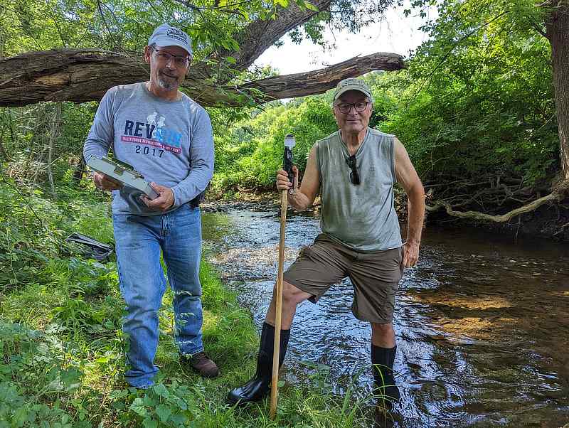 George Seeds and Joe Debes standing next to a stream.