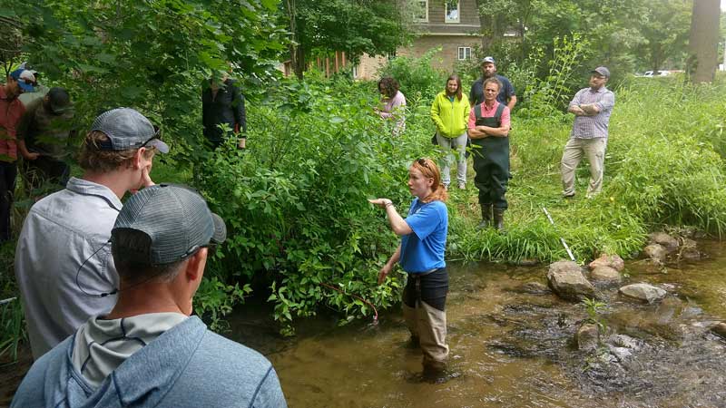 Rachel Johnson instructs members from Trout Unlimited on how to install water-quality monitoring probes in Rum Creek, Rockford, Michigan.
