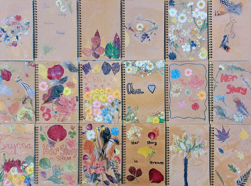 HerStory in STREAM journals decorated with leaves and flowers.