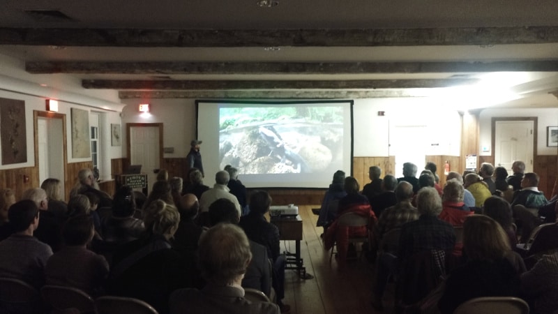 Jeremy Monroe shows a photo of a hellbender salamander to a standing-room-only crowd at the Stroud Center.