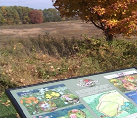 Interpretive signage at the edge of a meadow at Longwood Gardens.