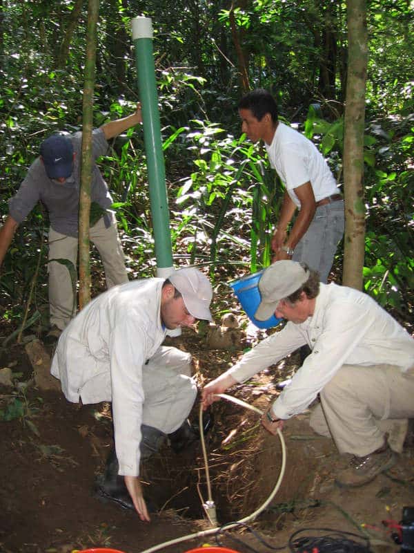 Scientists install device to sample groundwater near a Costa Rican stream.