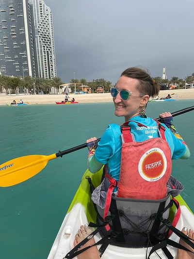 A kayaker looks back over her shoulder while paddling on a waterway in Dubai.