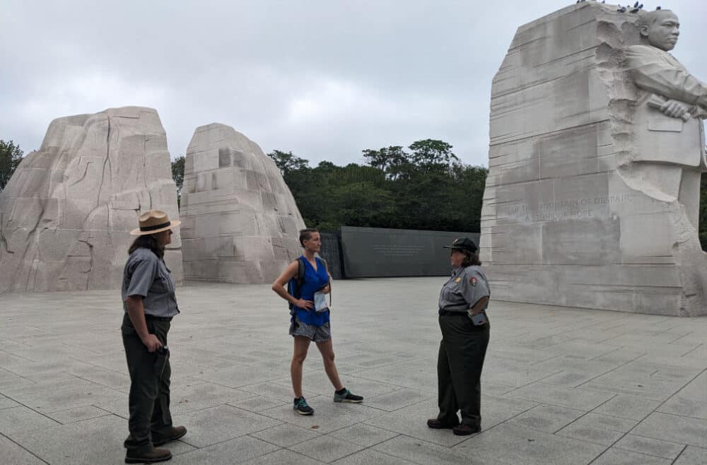 Kathryn Metzker stands with two National Park Service rangers at the Martin Luther King Jr. Memorial on the National Mall.