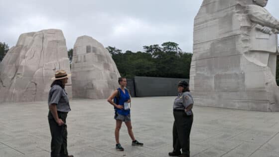 Kathryn Metzker stands with two National Park Service rangers at the Martin Luther King Jr. Memorial on the National Mall.