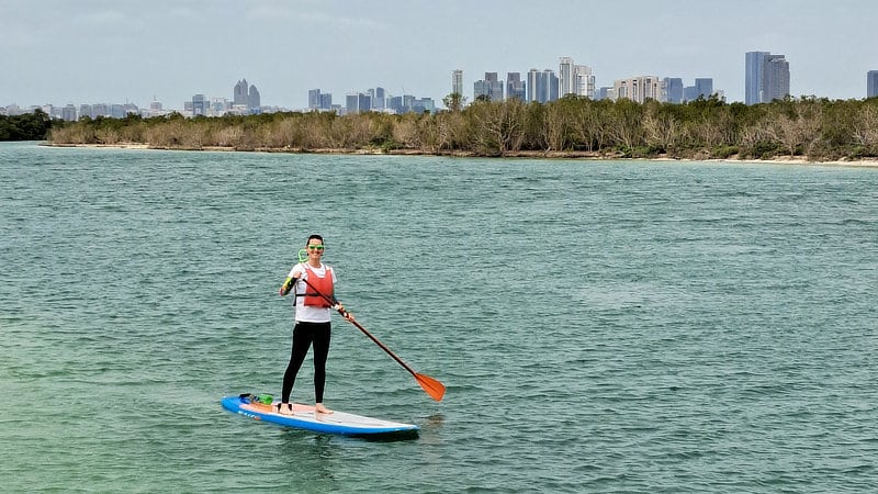 A woman on a stand-up paddleboard on a waterway in Dubai.