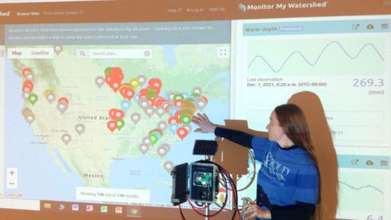 A woman demonstrates how Monitor My Watershed displays real-time data.