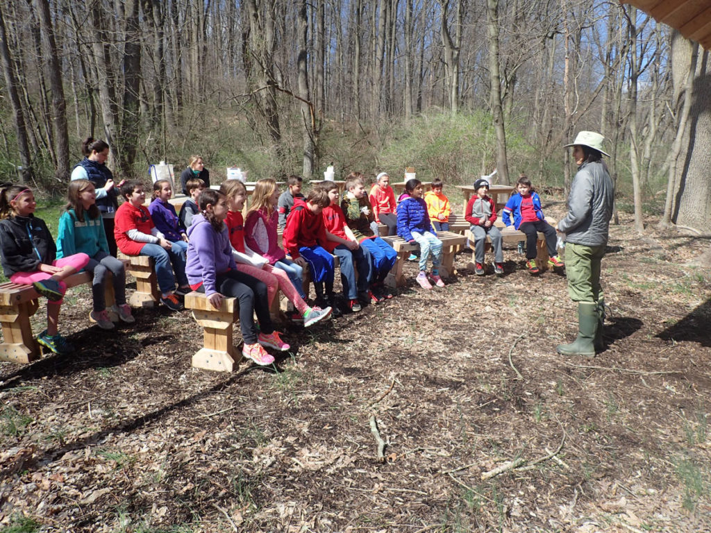 Tara Muenz teaching a group of students in the outdoor classroom.