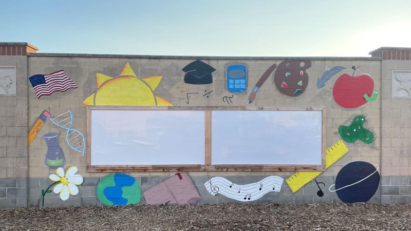 A mural and whiteboards in an outdoor classroom.