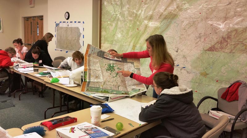 People looking at a large watershed map
