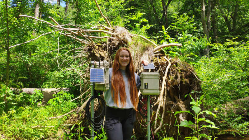 Rachel Johnson standing between two EnviroDIY Monitoring Stations.